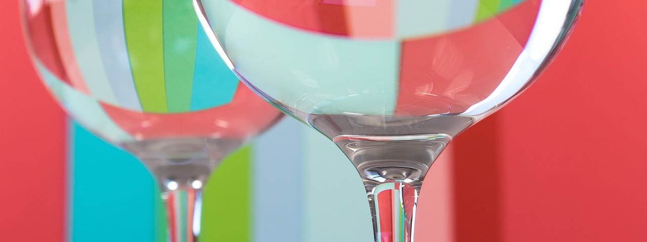 Two wine glasses in the foreground bend the colours and patterns showing in the background