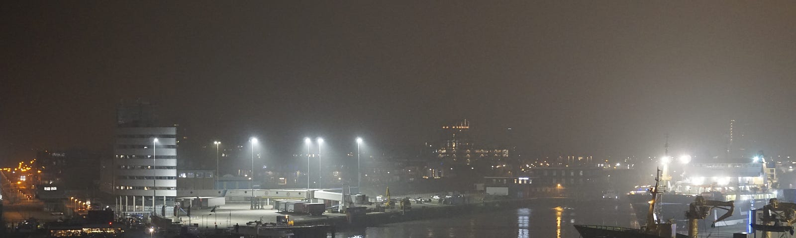 Mist covers the harbour at night.