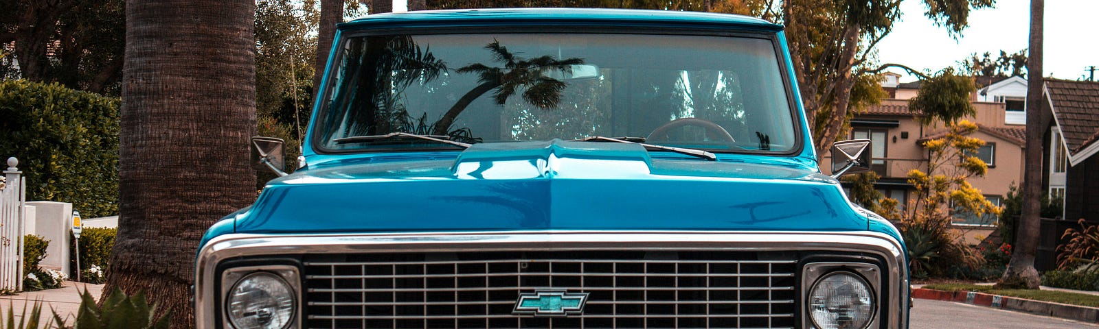 Front view of an older, blue Chevy truck