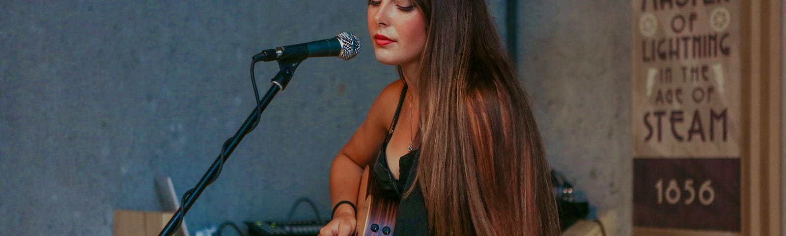 A woman playing a guitar. The lack of interest in alcohol is starting to hit the music industry.