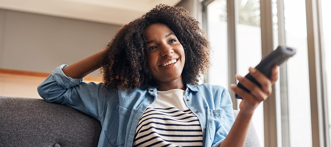 Young woman watching connected TV in living room