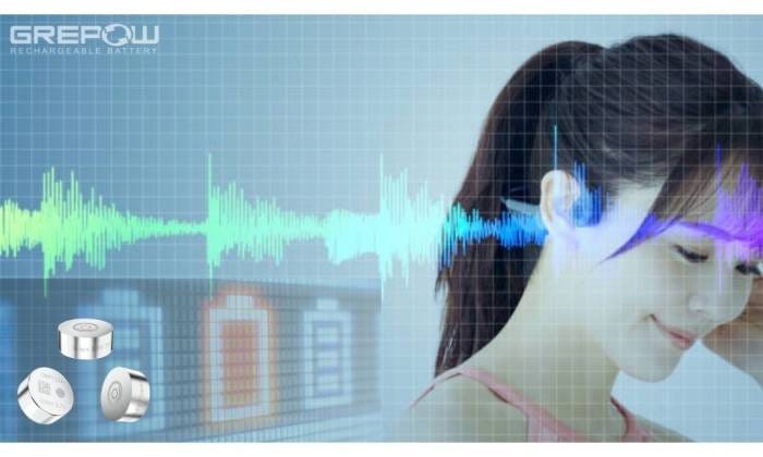 A smiling girl with hearing aids powered by button cells