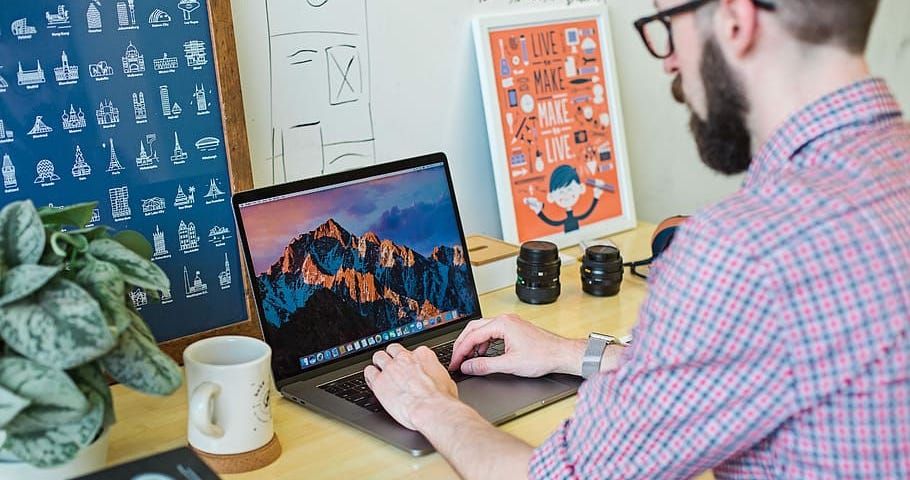 Man typing on Laptop with Coffee