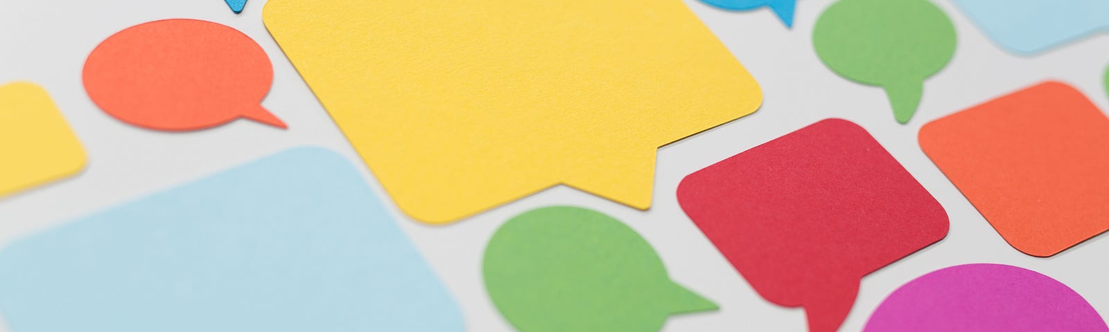 image of a variety of colorful speech bubble paper cut-outs on a white background