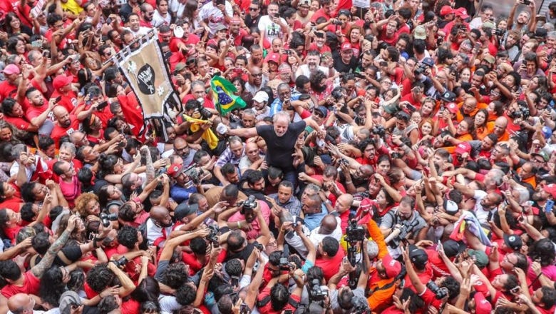 photo by Ricardo Stuckert shows Lula smiling and being carried by the people