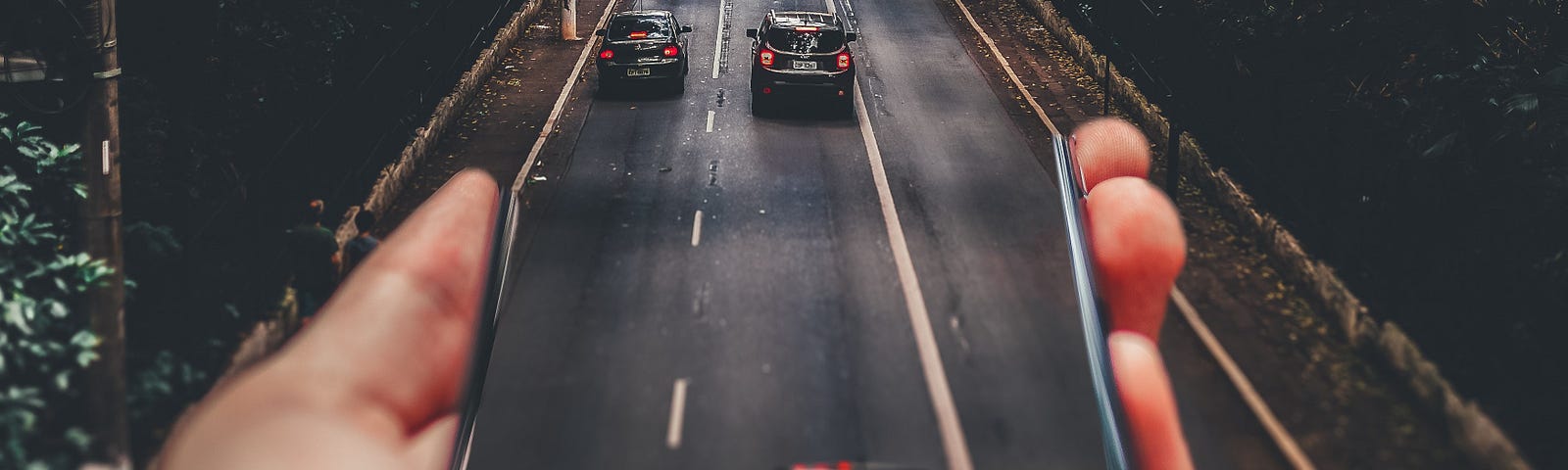 A hand grabs a cellphone from where we see cars leaving to a street, making referrence to web Augmented Reality, or web AR | Adapted photo of Matheus Bertelli, available in Pexels.