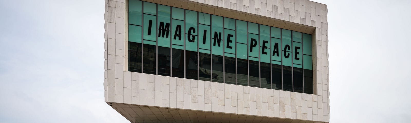 ‘Imagine Peace’ posted up in the windows of a large museum building.