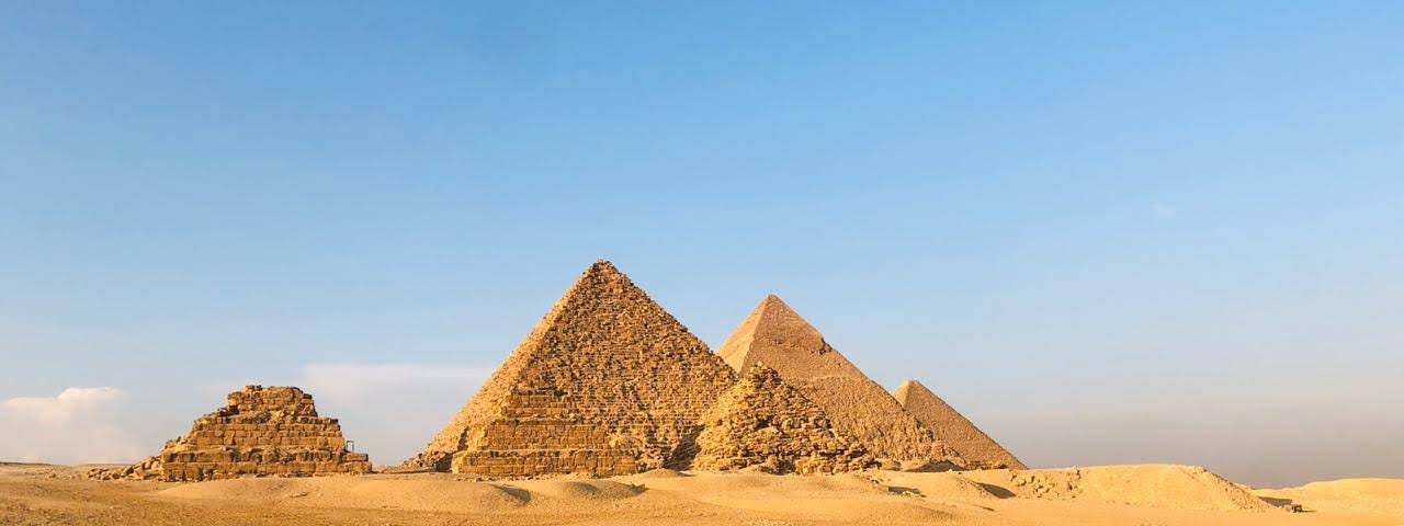 The Great Pyramids of Giza with author walking in the sand