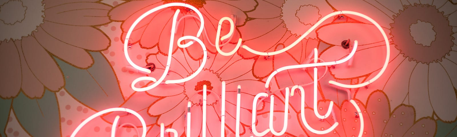 A neon sign saying “be brilliant”