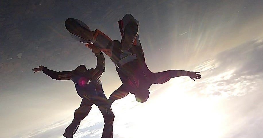 Skydivers fall as if into the sun