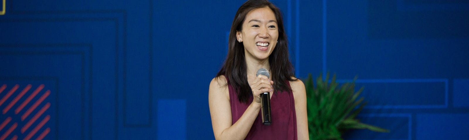 An image of Belinda Chiu speaking on a stage