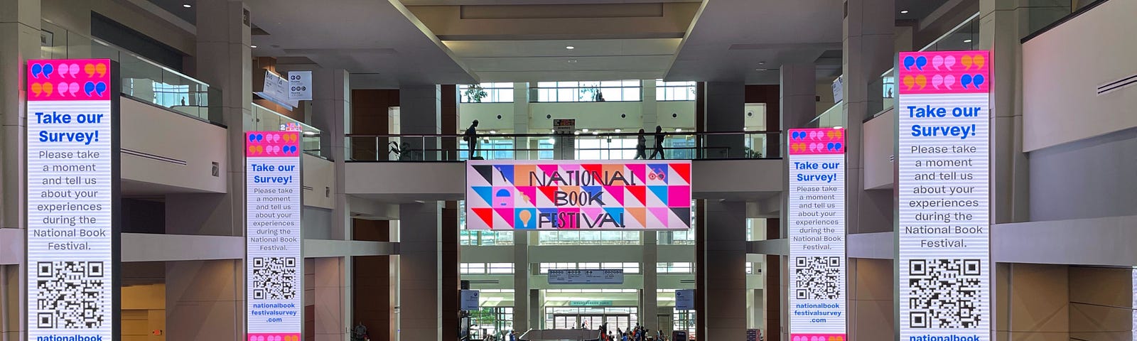 A busy convention center with a “National Book Conference” banner in the background