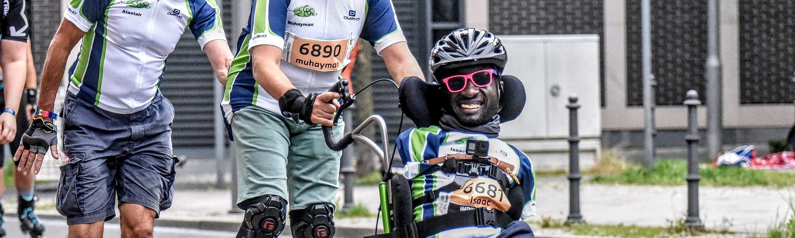 Three men, two rollerblading and one in a wheelchair, are participating in a race.