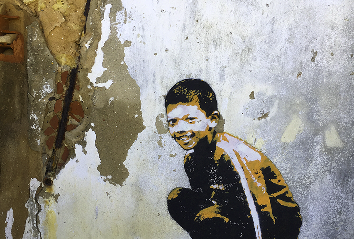 Street art shows a boy crouching.