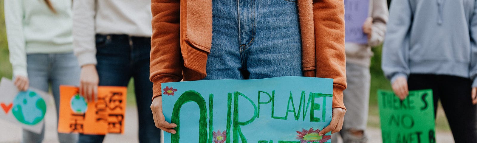 O femeie ține un afiș pe care scrie Planeta noastră, viitorul nostru.