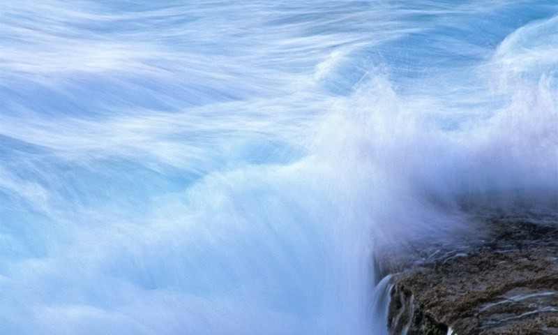 Photograph of water crashing on rock, slow shutter speed, for healing