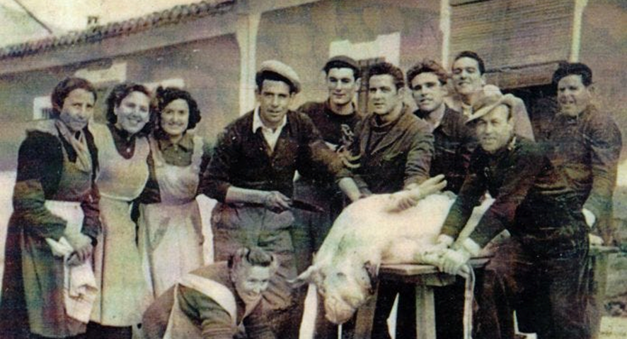 The Pig’s Slaugher. A group of men and women posing for a photograph with a dead pig