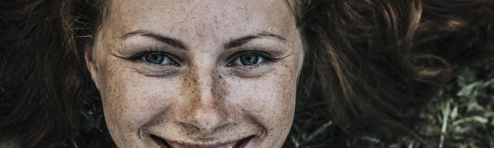 Portrait of young woman, smiling. freckles.