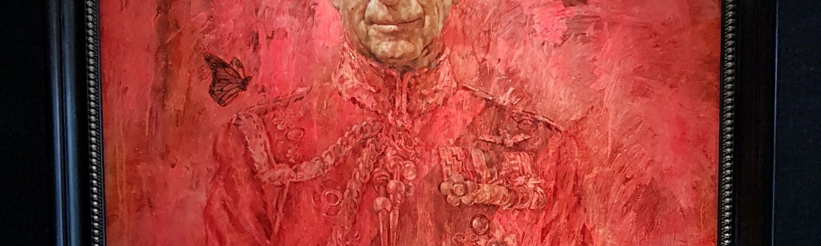 Portrait of King Charles III in red with a black frame, showing his face in natural colouring.