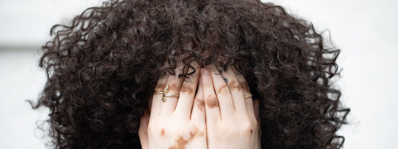 curly hair, beautiful woman, covered eyes, hands