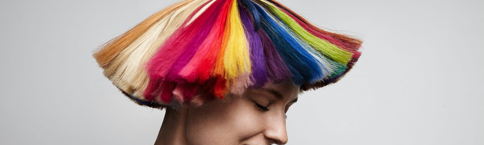 Pictured is a woman with rainbow colored hair