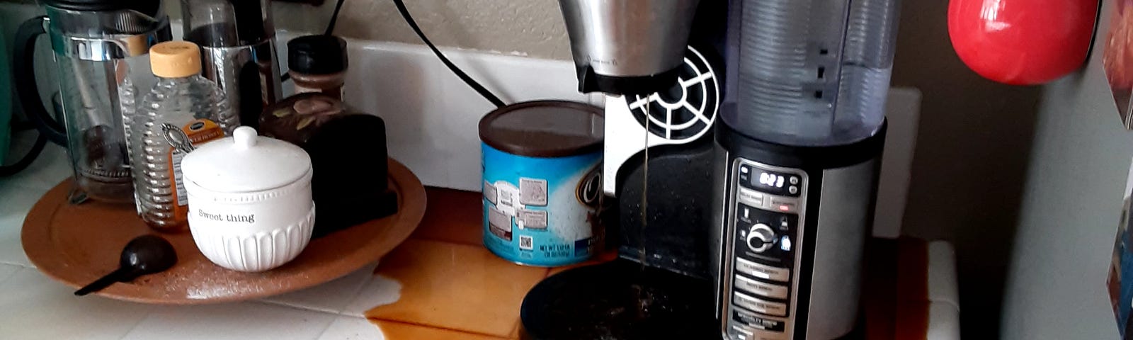 My real-life coffeemaker  without a carafe, coffee spilled widely over the countertop.