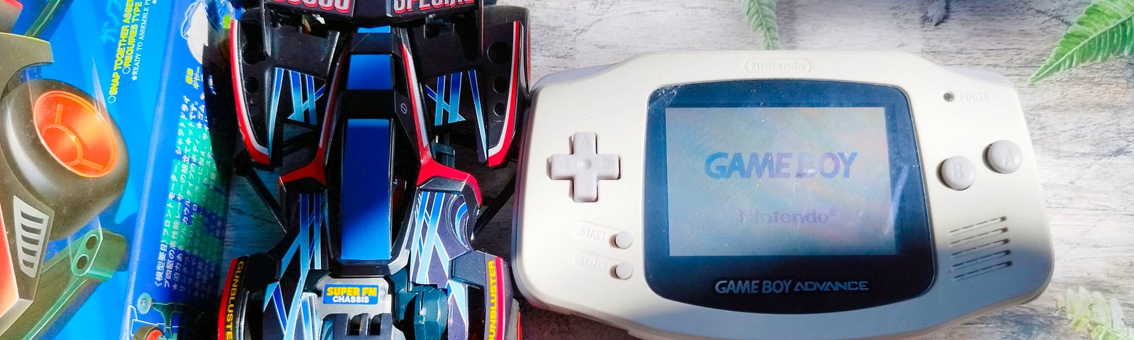 A Tamiya toy car and a Game Boy Advance on top of a table