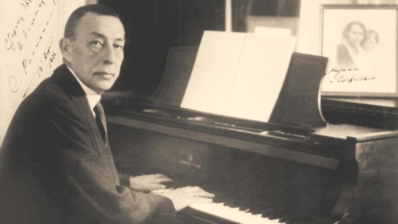 Black and white image of composer, musician, conductor Sergei Rachmaninoff sitting at the piano