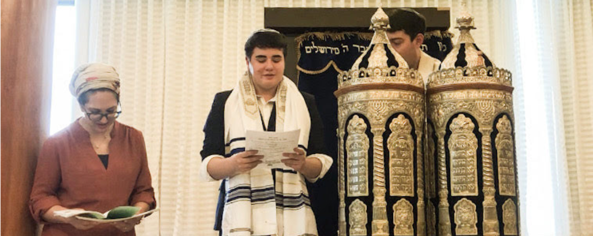 Isaac having a Bar Mitzvah in Israel next to a torah and a woman.