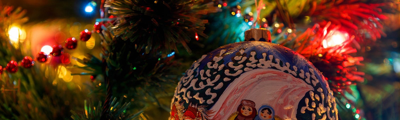 An ornament depicting a sleigh ride hangs from a tree.