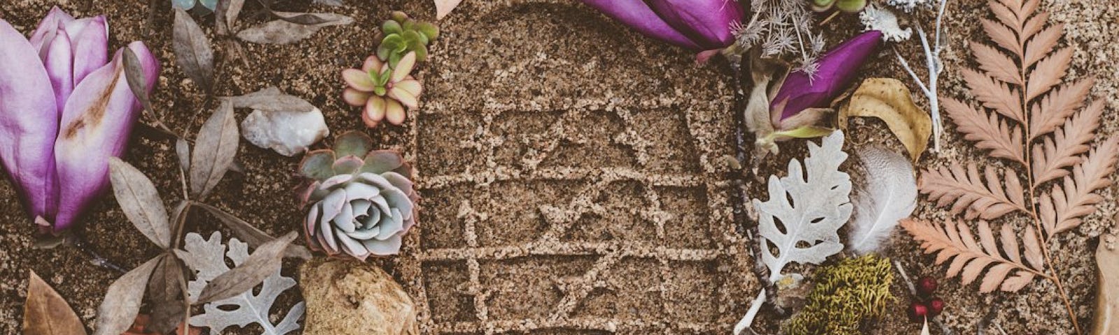 A footprint in the sand, surrounded by shells, flowers, leaves of pink and lavender. A female vibe.