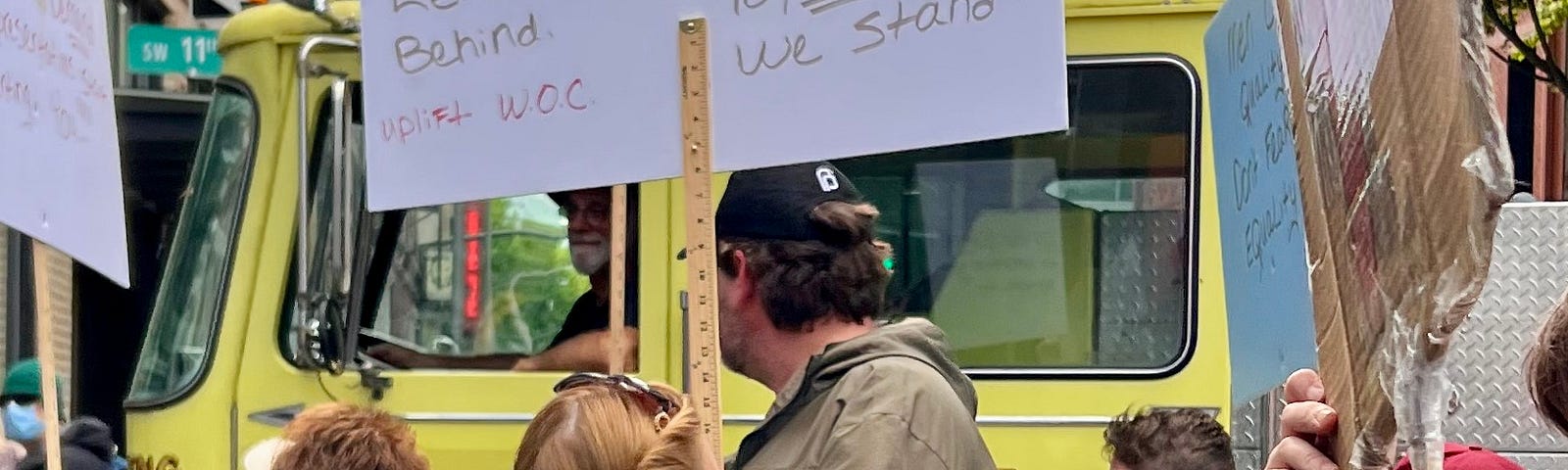 Woman (named Candy) with sign reading: All women are on the brink of losing our rights because we left women of color behind. Together we stand. Uplift WOC