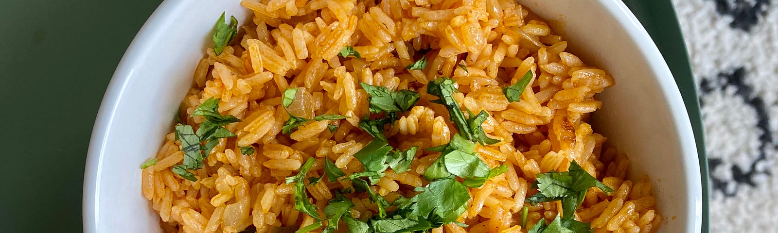 a bowl of Spanish rice garnished with some parsley.