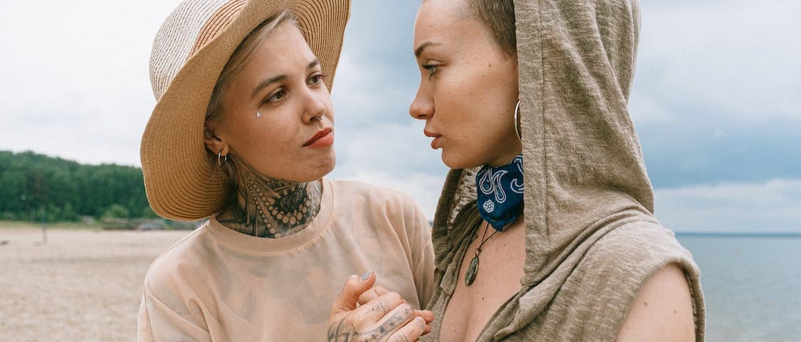 A woman is holding another woman’s hands in a consoling manner