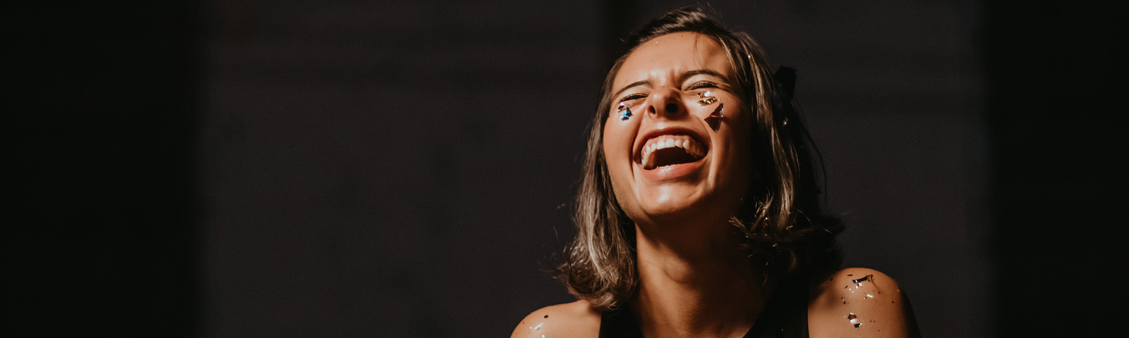 Image of a girl smiling with eyes closed and paint on her face