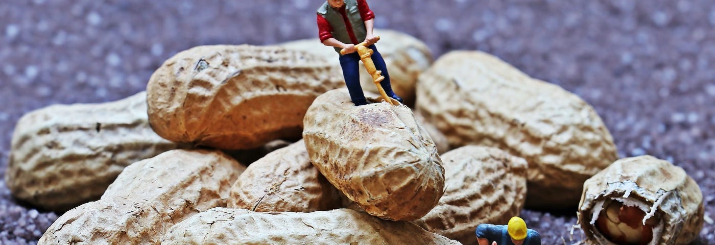 Image: Toy workers breaking apart peanuts with a tiny plastic jackhammer.