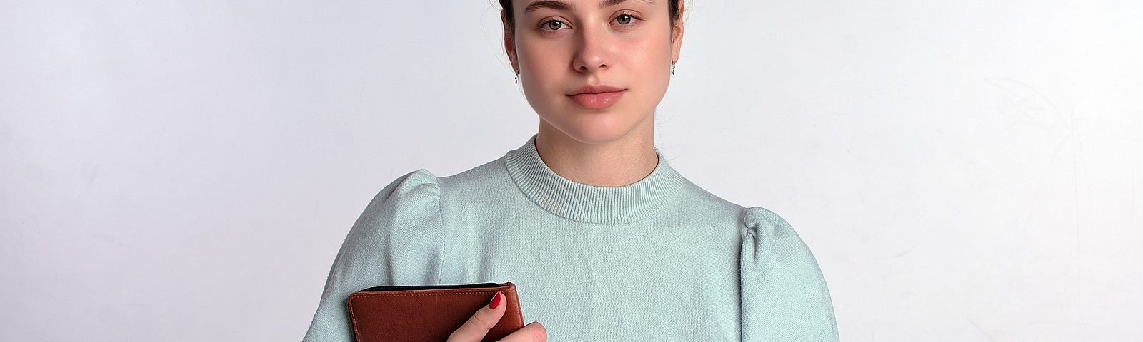 A woman standing with a brown diary in her hands