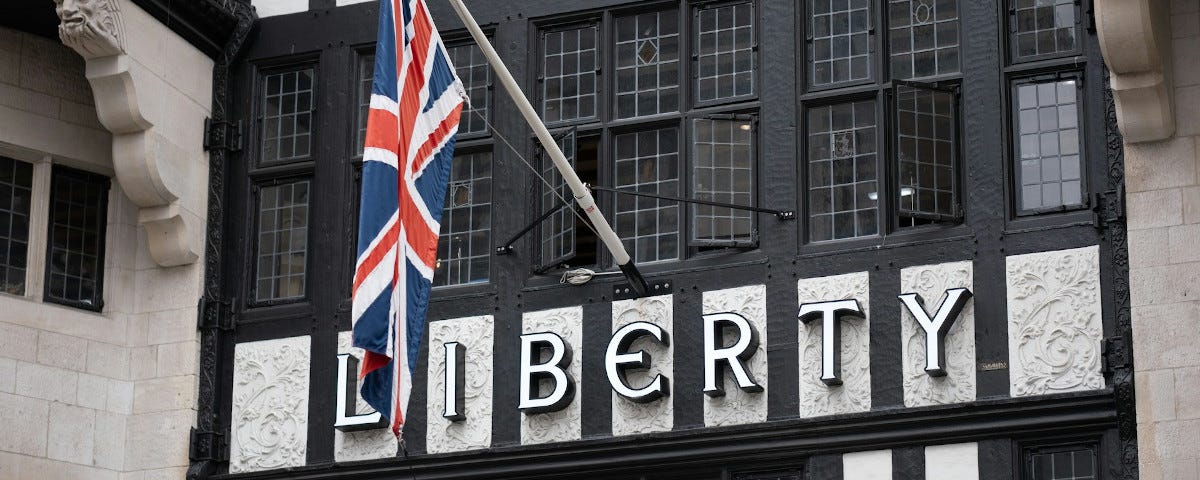 A Tudor-style storefront on Regents Street, London. A Union flag hangs above the store’s name, “Liberty”.