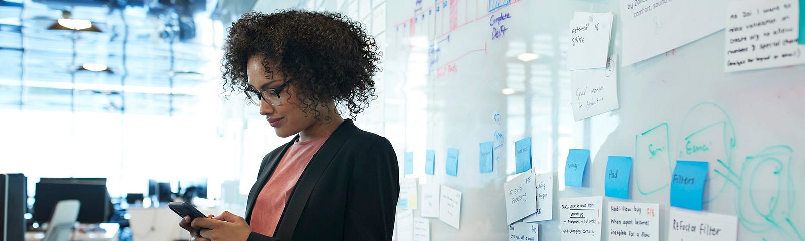 An individual stands next to a white board.