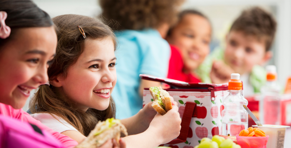 Students eat lunch at a table.