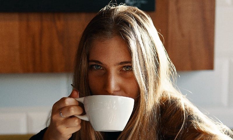 A young woman drinking a cup of coffee