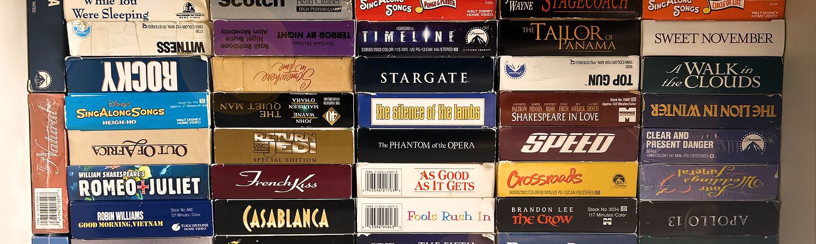 A full bookshelf of VHS tapes of classic movies.