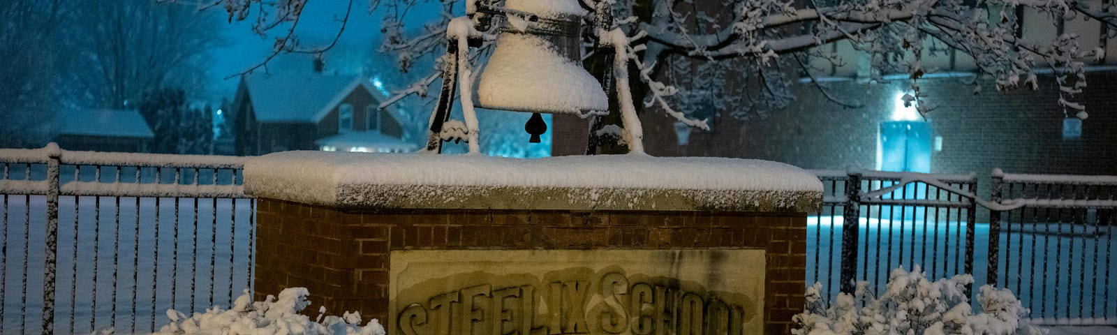 Image of a school bell covered in snow