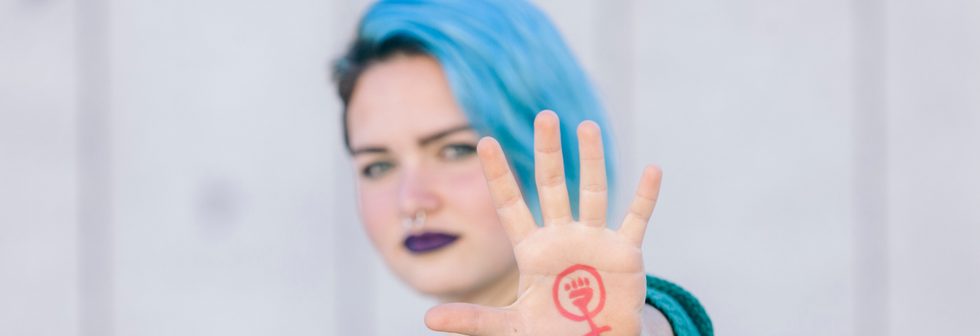 A women showing the feminism symbol on her hand.