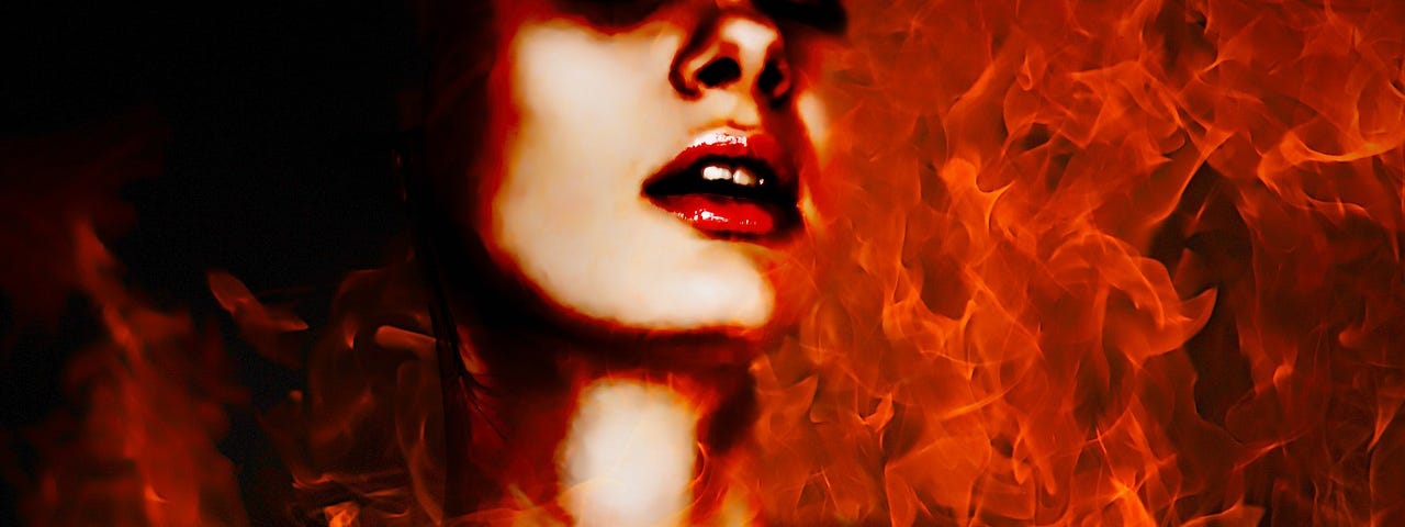 Model, young woman, head and shoulders, gives the illusion she is engulfed with flame, red lipstick