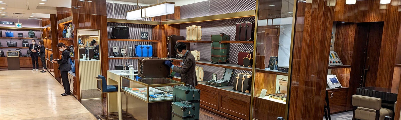 Upscale department store with gloved salesperson selling leather suitcases. If you have to ask the price, you can’t afford it, dear