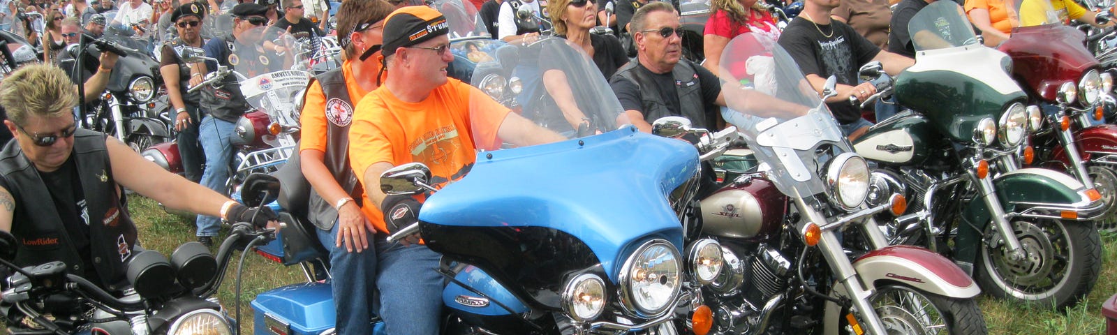 This photo shows hundreds of motorcyclists sitting on their motorcycles.