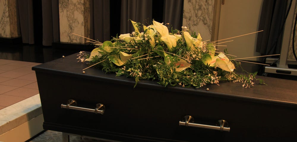 White lillies on a dark wooden coffin