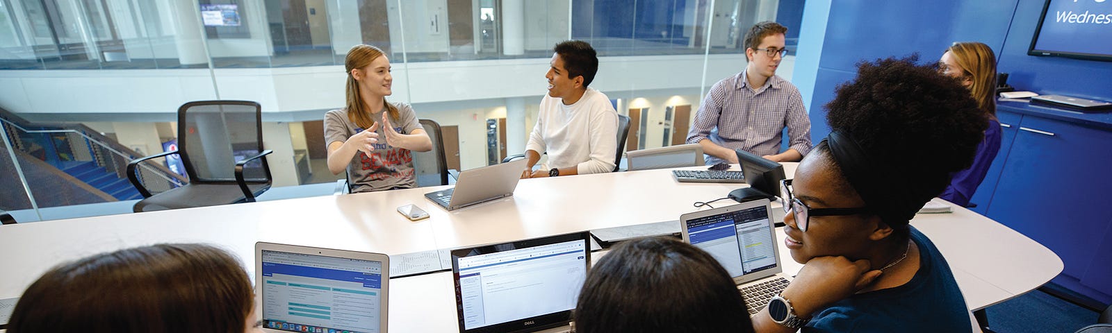 Students are seated around a conference table with laptops in a fourth-floor conference room in Capitol Federal Hall