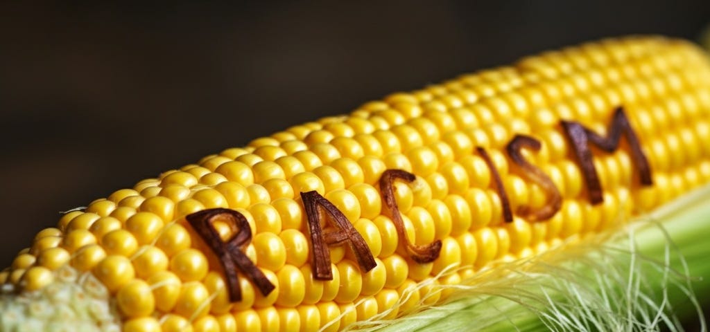 AI-Generated image of corn on the cob with the word racism imbedded in before we eat and digest it